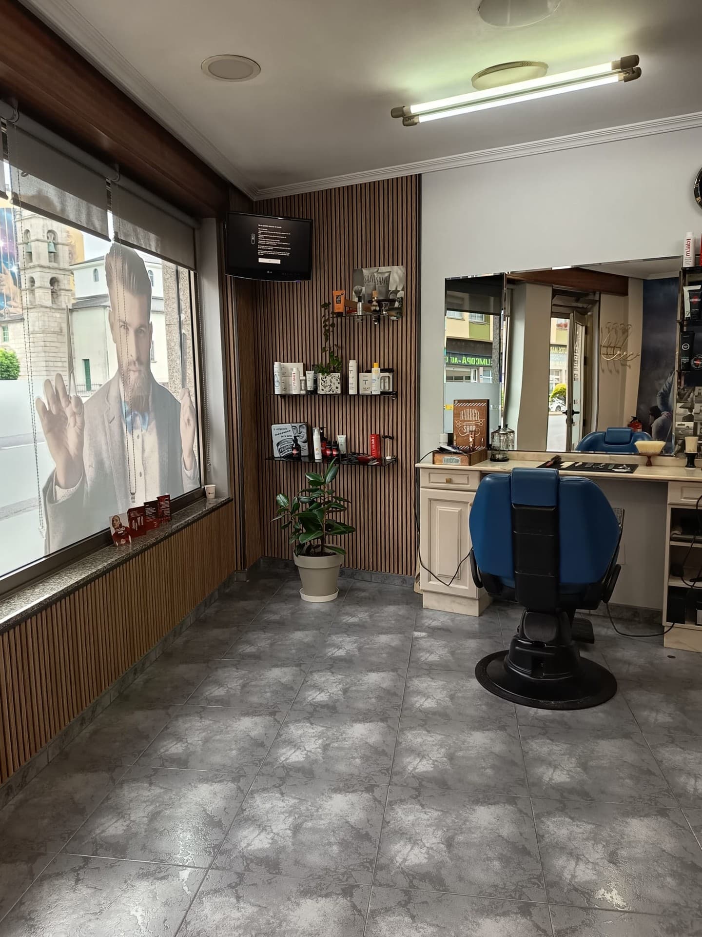 Peluquero cortando el pelo a un cliente en Peluquería Villamayor en Fene